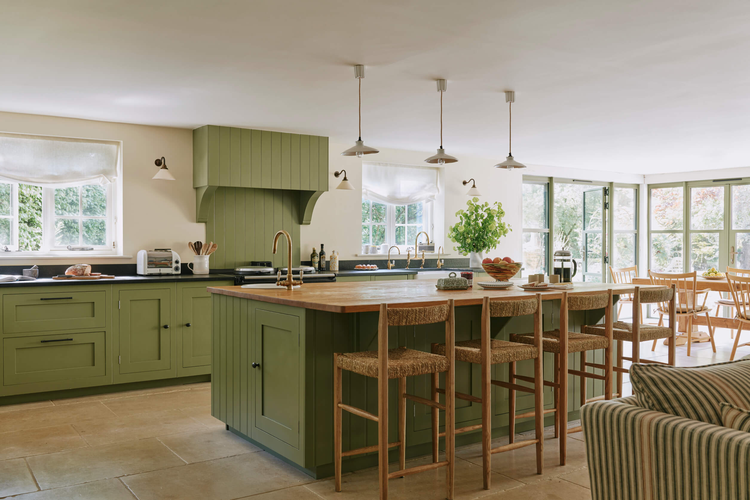 Green painted kitchen in a large country kitchen, interior design by Studio Squire