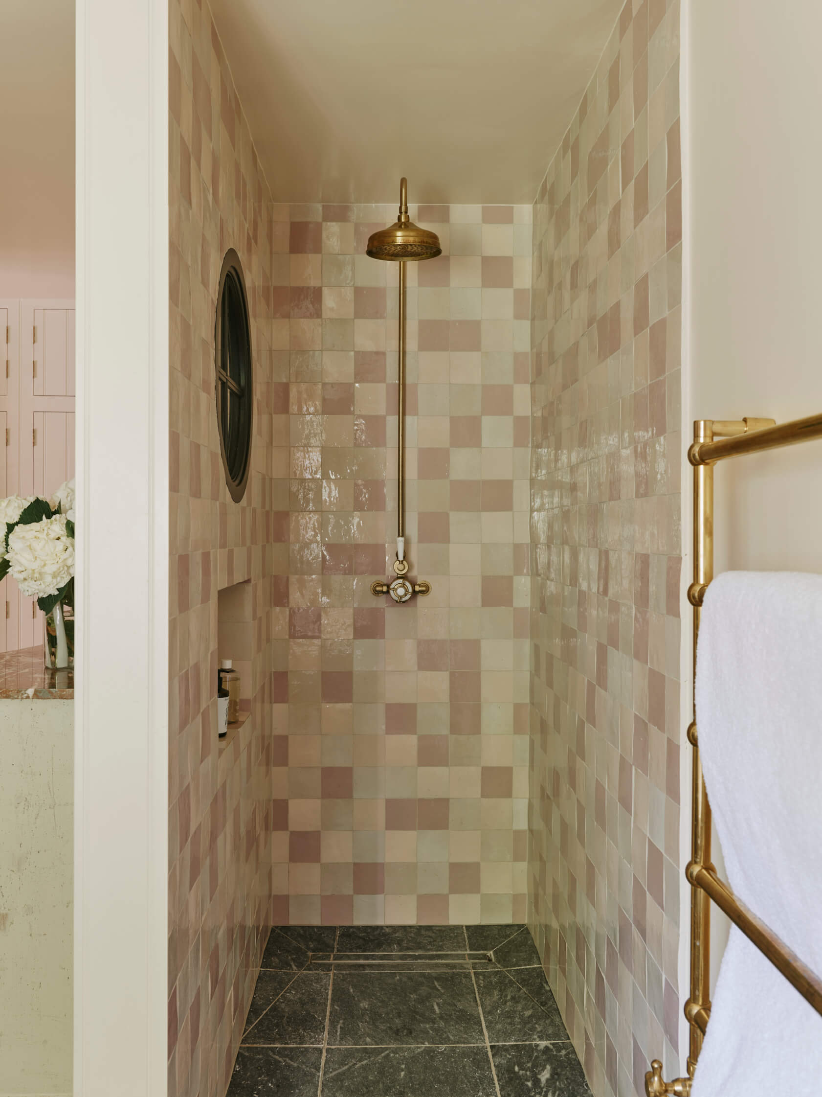 Tilled shower with gold shower head and towel rail. Designed by Studio Squire interior designers