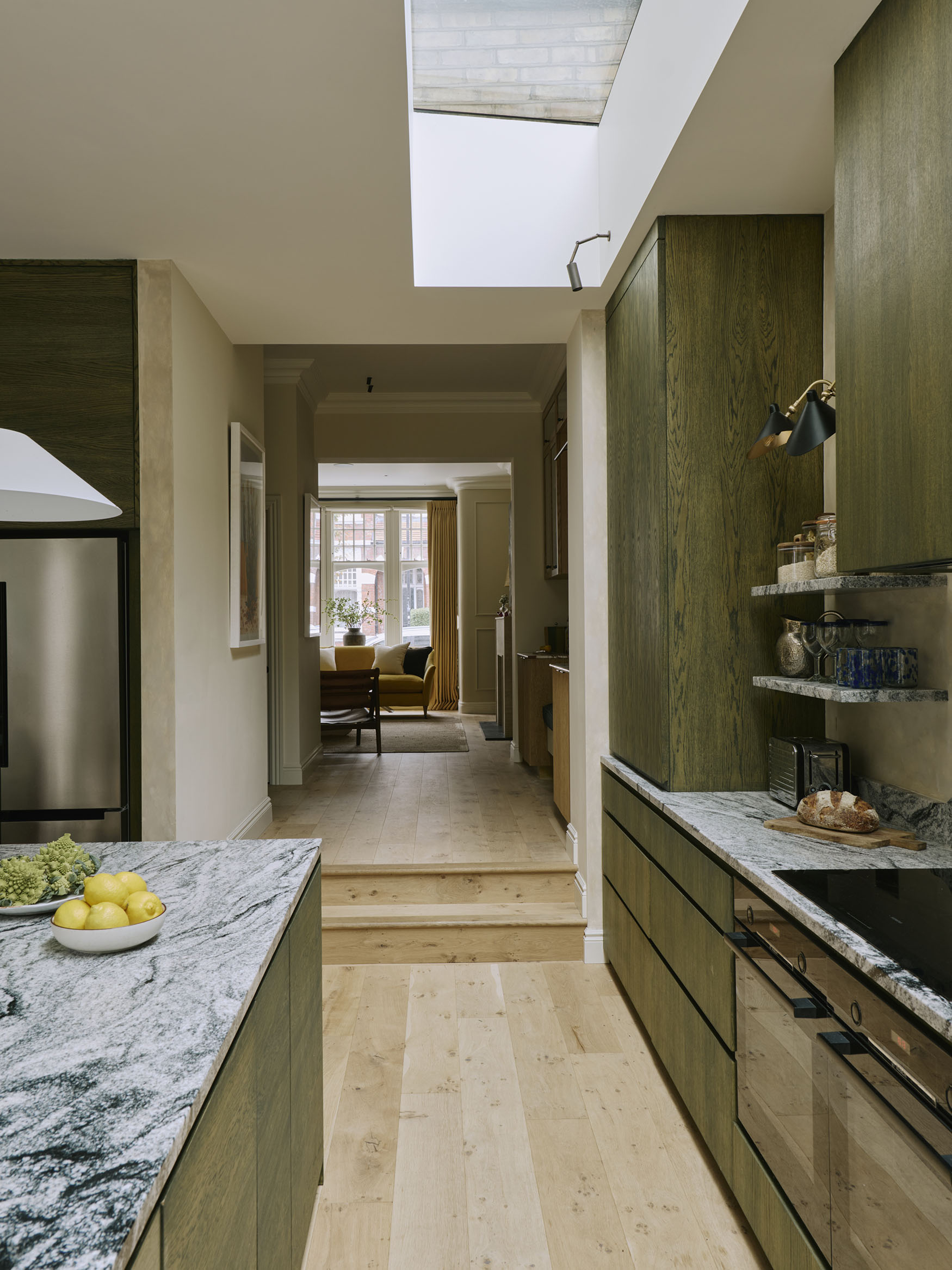 Image looking through a kitchen and hallway into a sitting room, interior design by Studio Squire