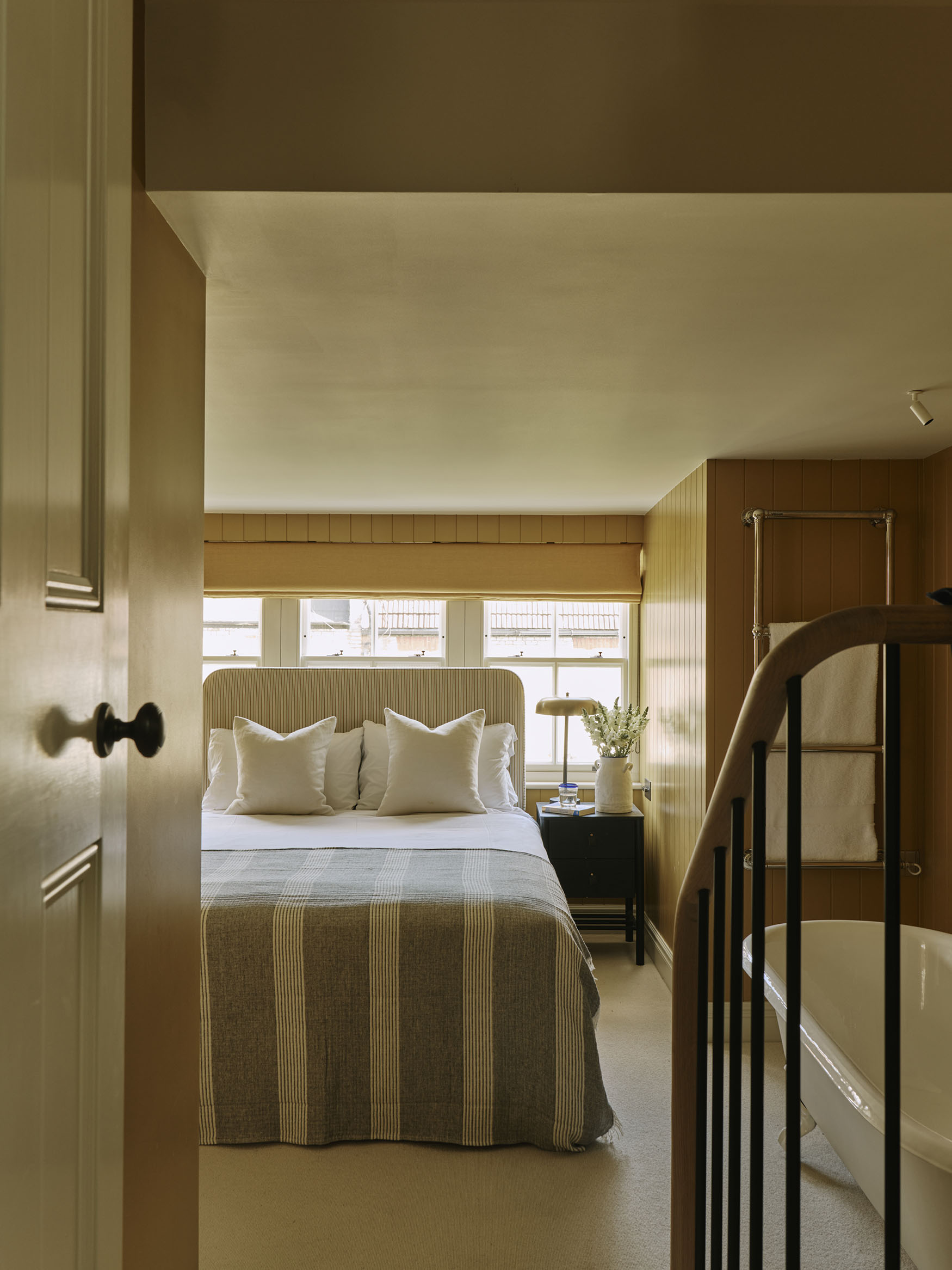 Looking through a door into a bedroom, interior design by Studio Squire