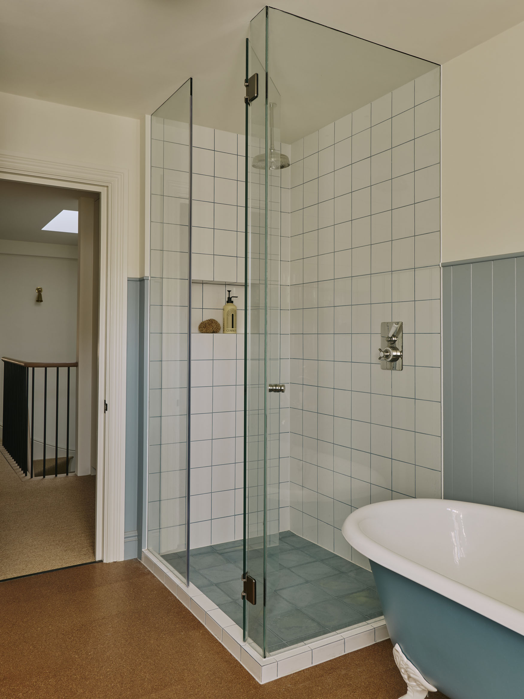 Shower and bath with blue details, interior design by Studio Squire